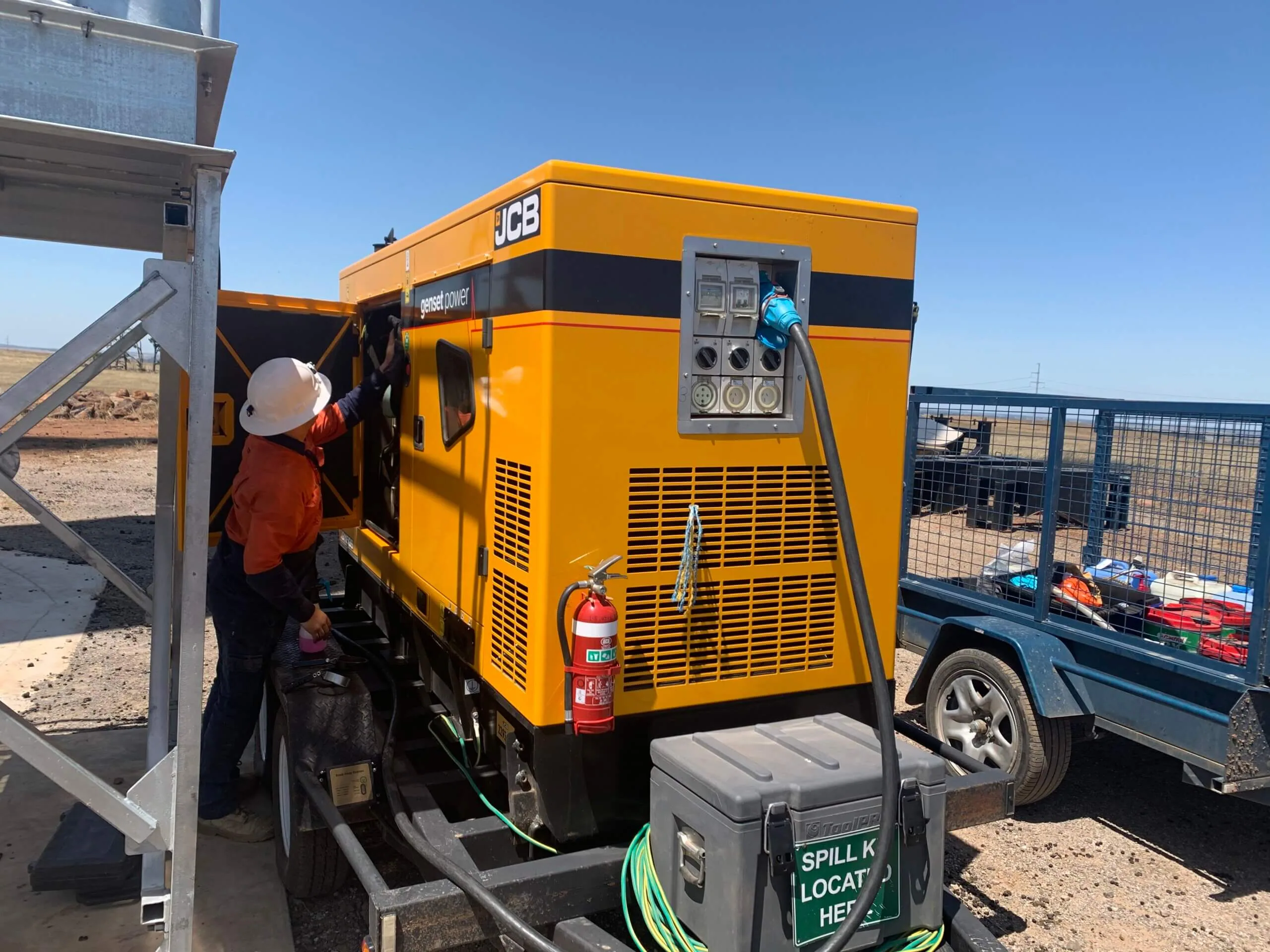 An Eastern Generators electrician connecting a JCB generator on a worksite