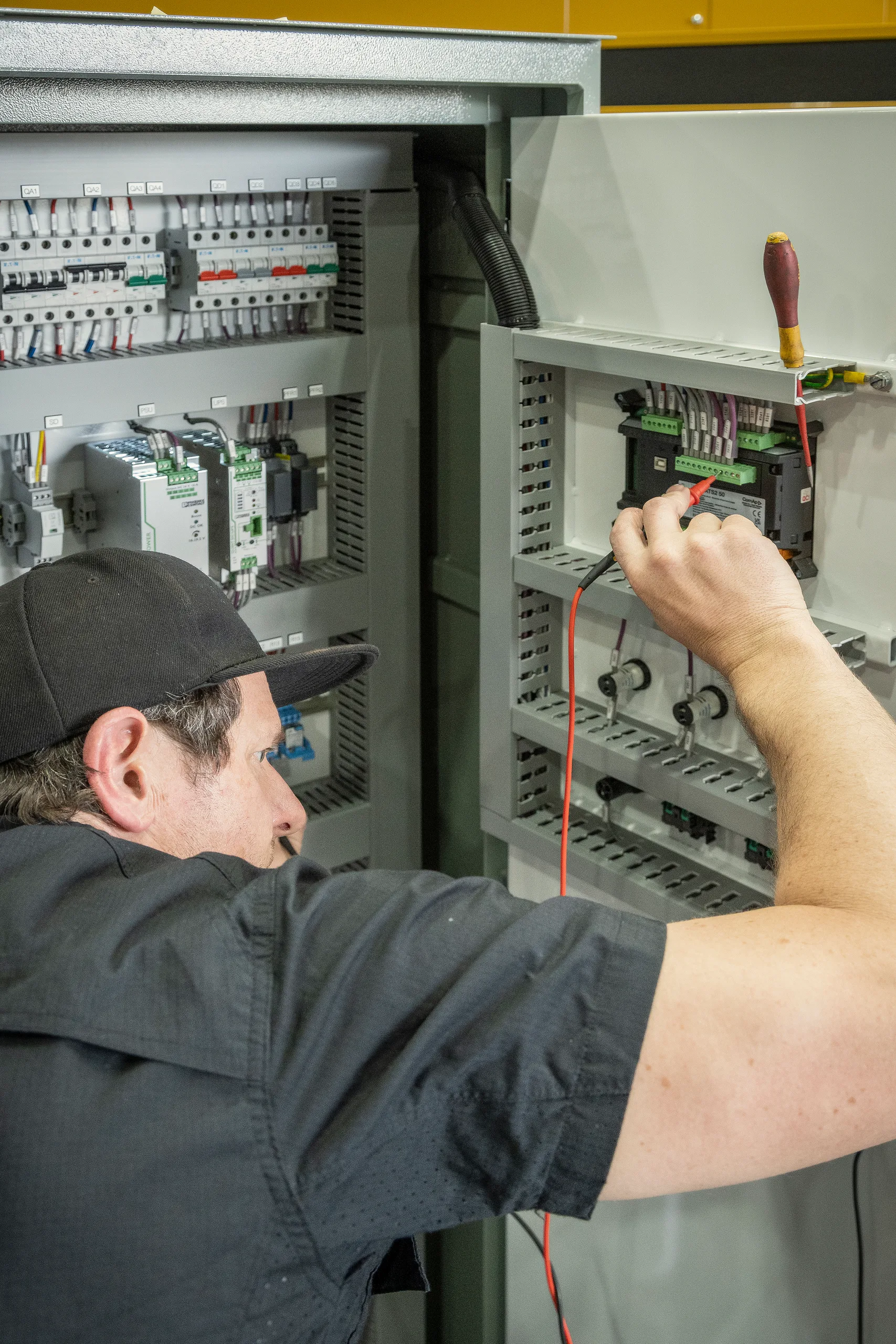 An Eastern Generators electrician working inside a distribution board