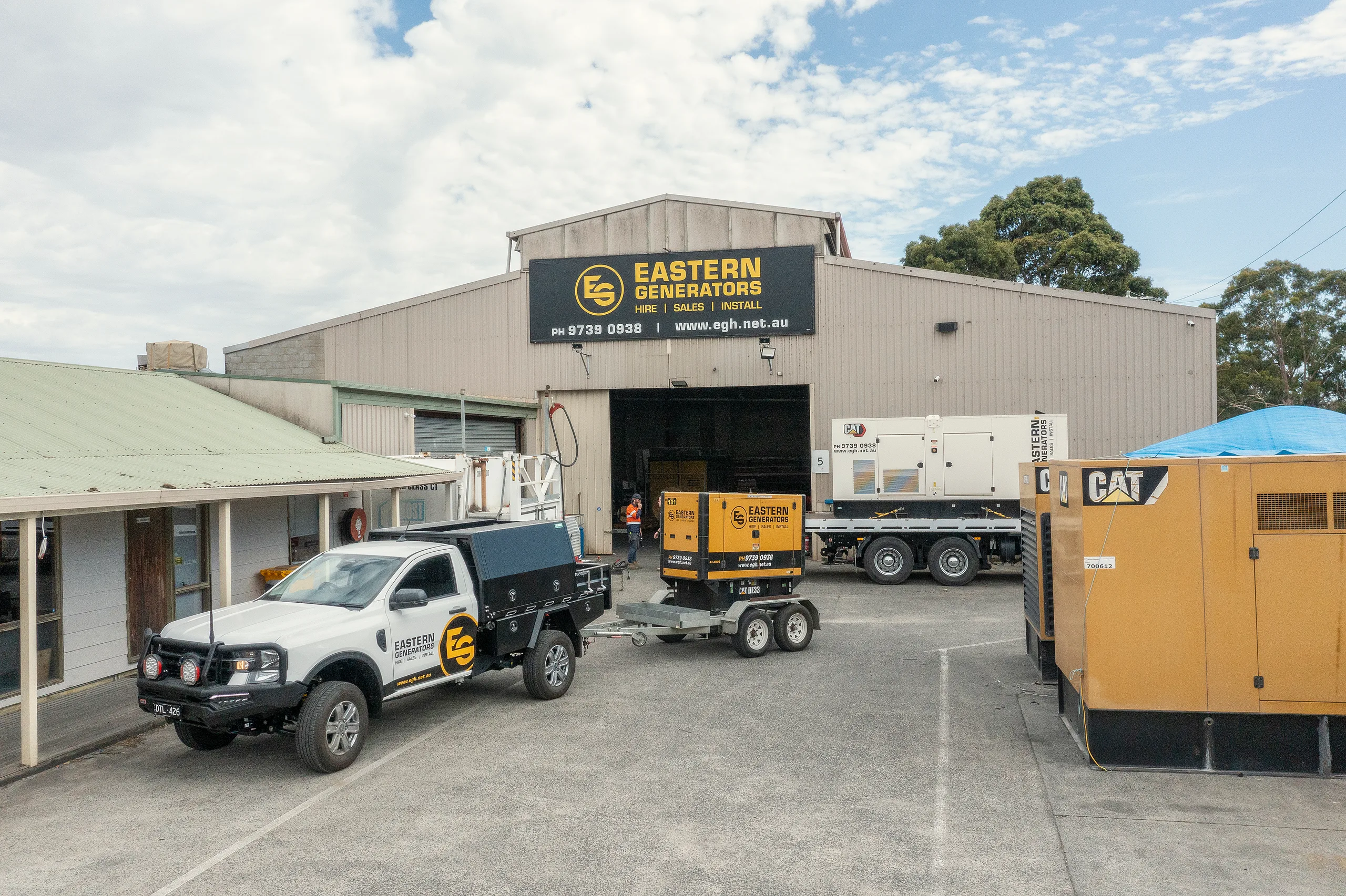 An Eastern Generators truck delivering a generator to a commercial building