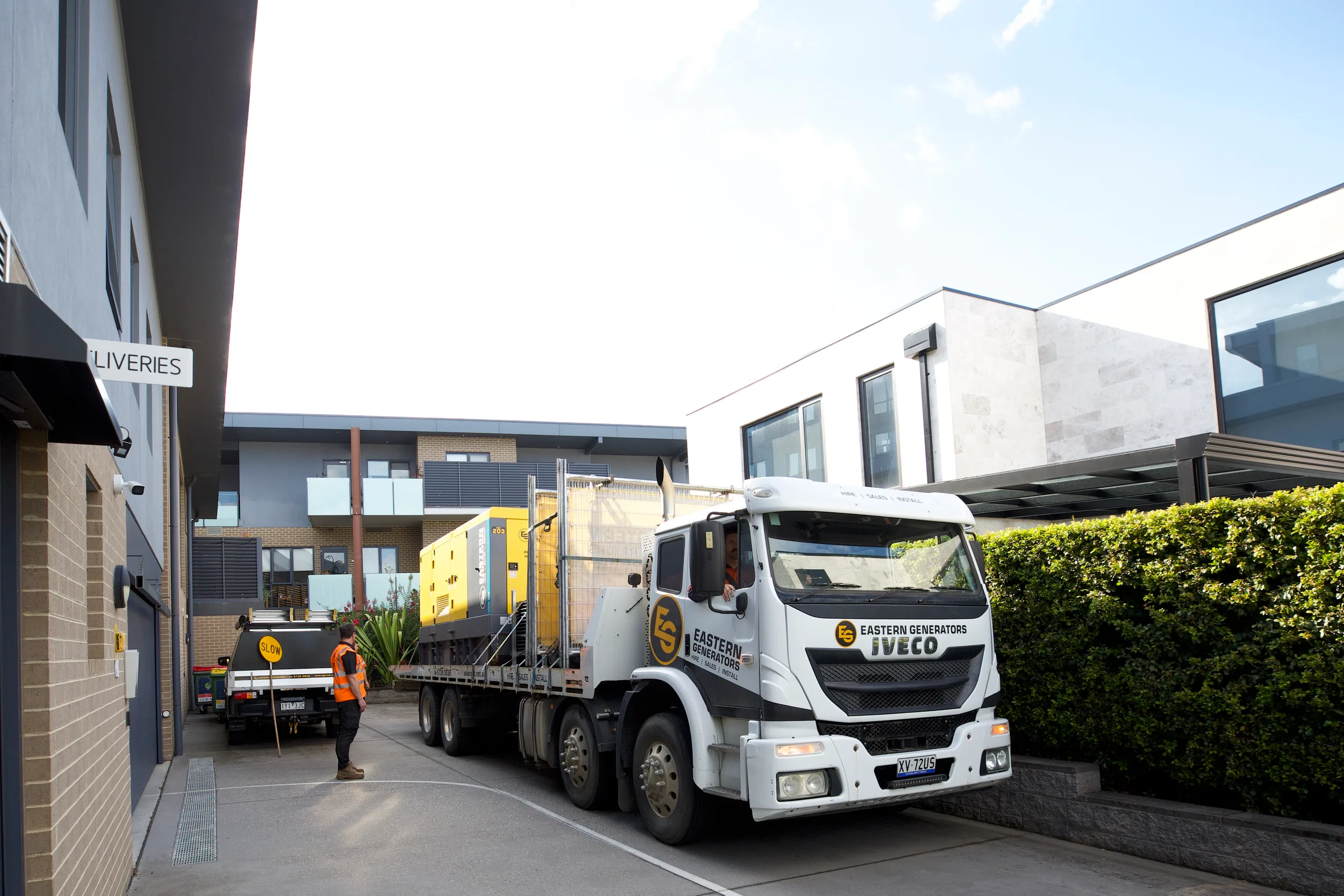 An Eastern Generators truck delivering a generator to a commercial building