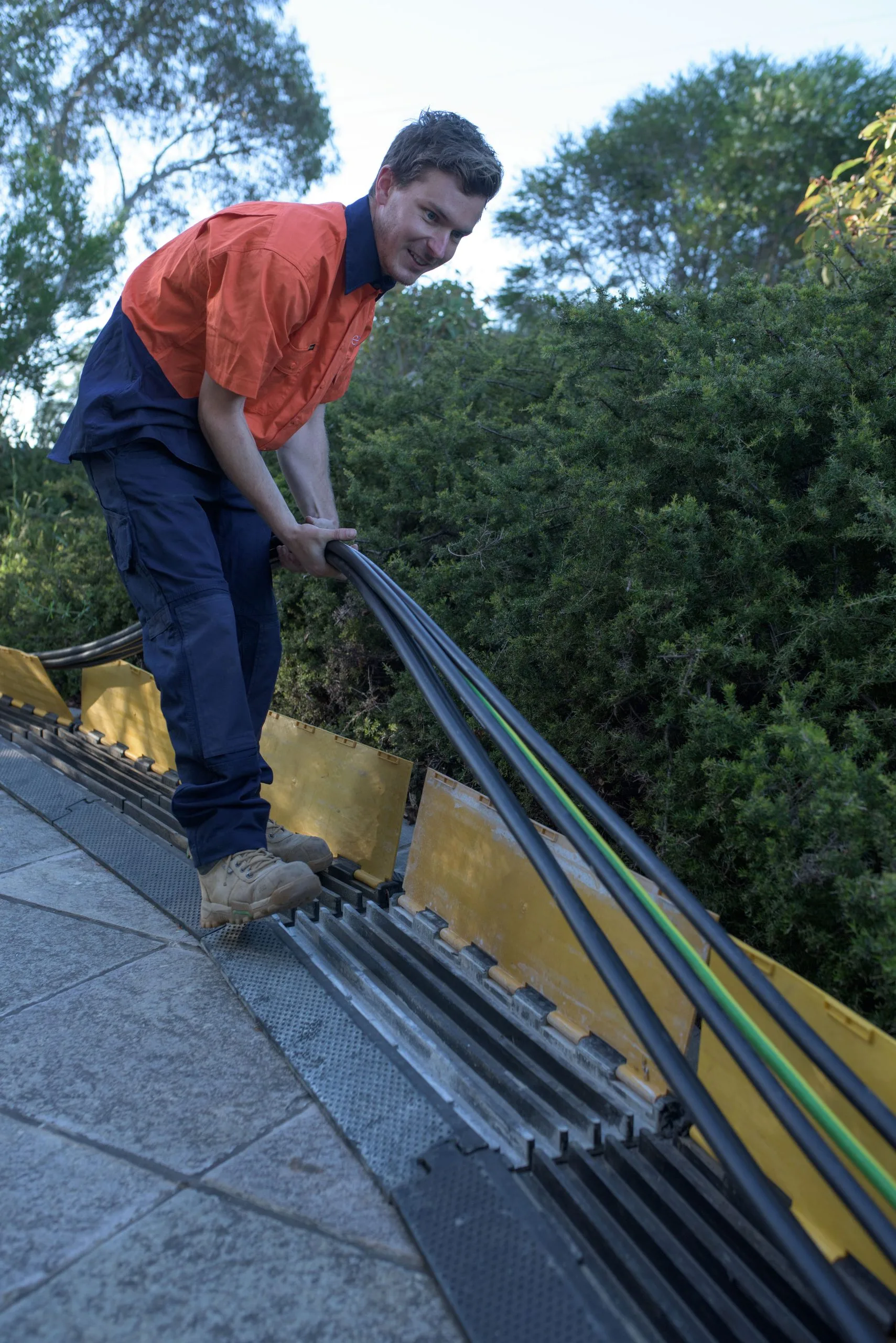 A technician running cable under a ramp on site