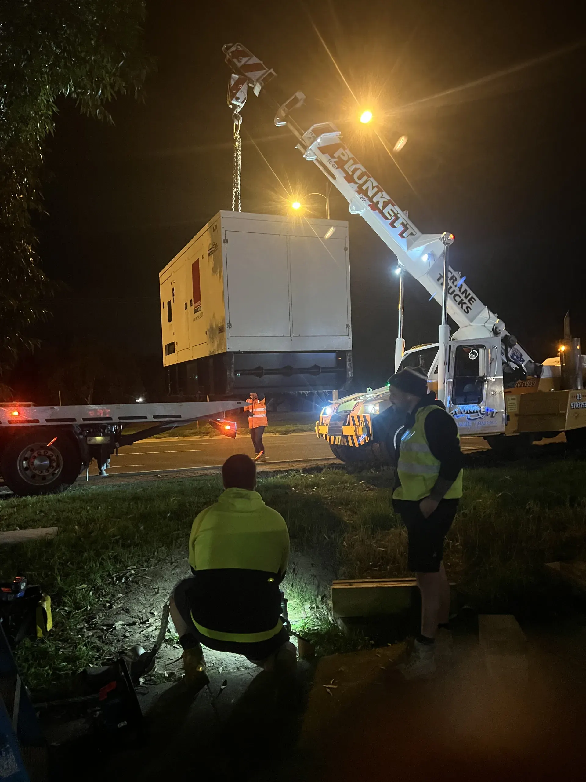 Night workers in reflective vests beside an Eastern Generators truck