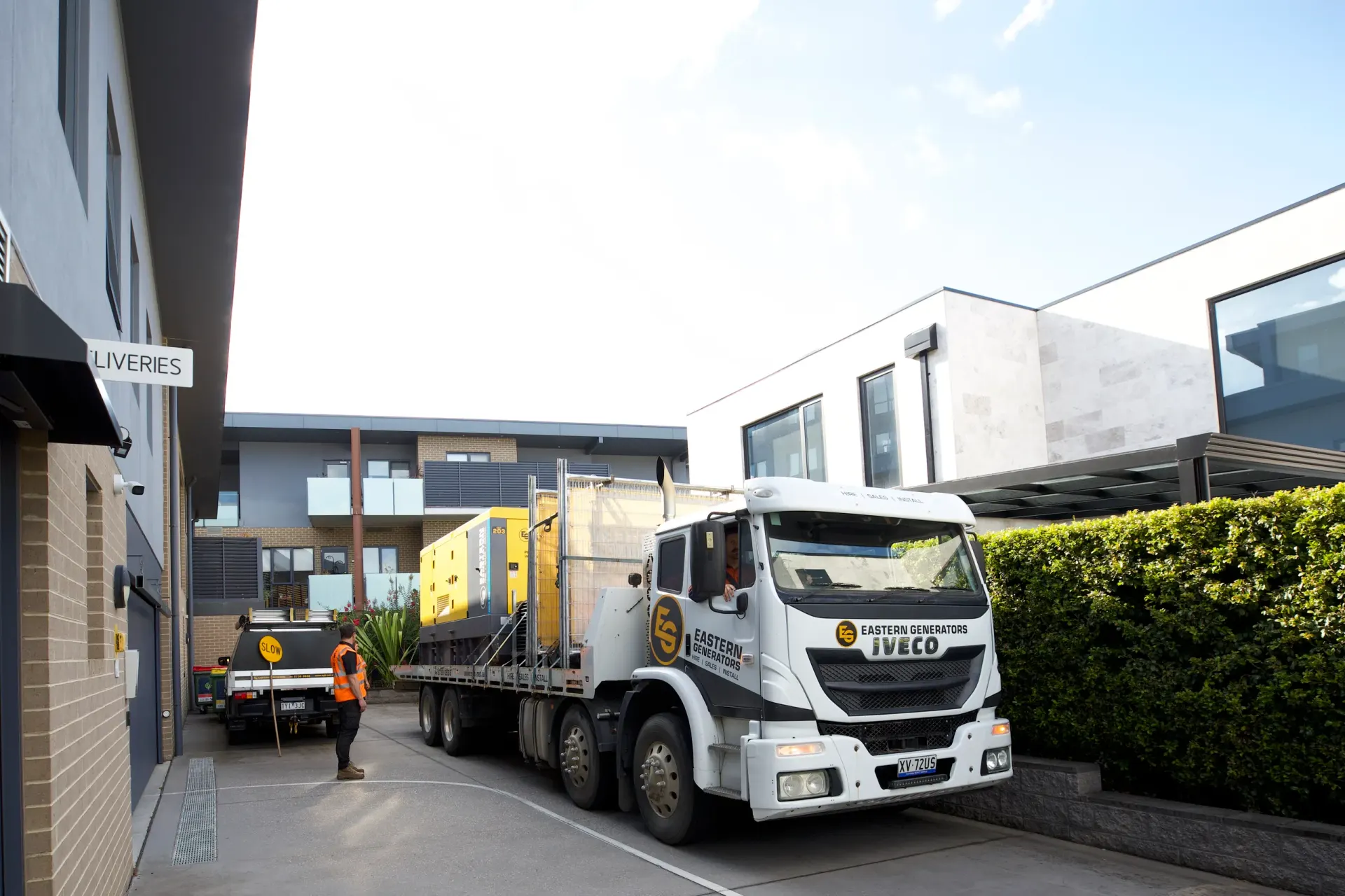 An Eastern Generators truck delivering a generator to a commercial building