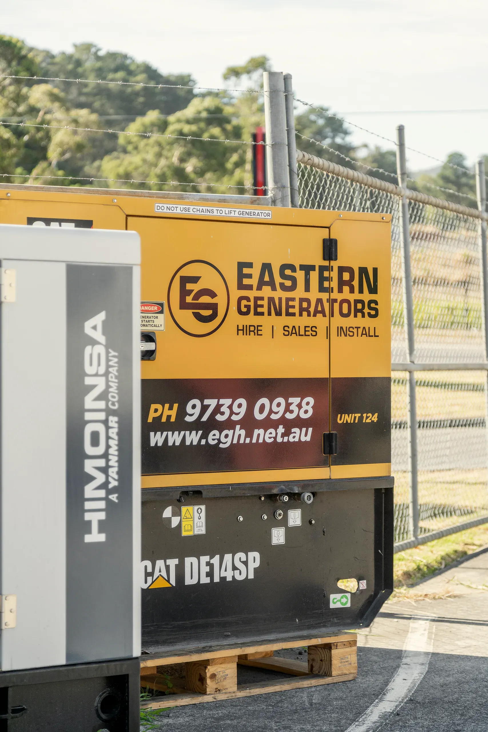 A small Caterpillar hire set in Eastern Generators livery, beside a Himoinsa unit in the Kilsyth yard
