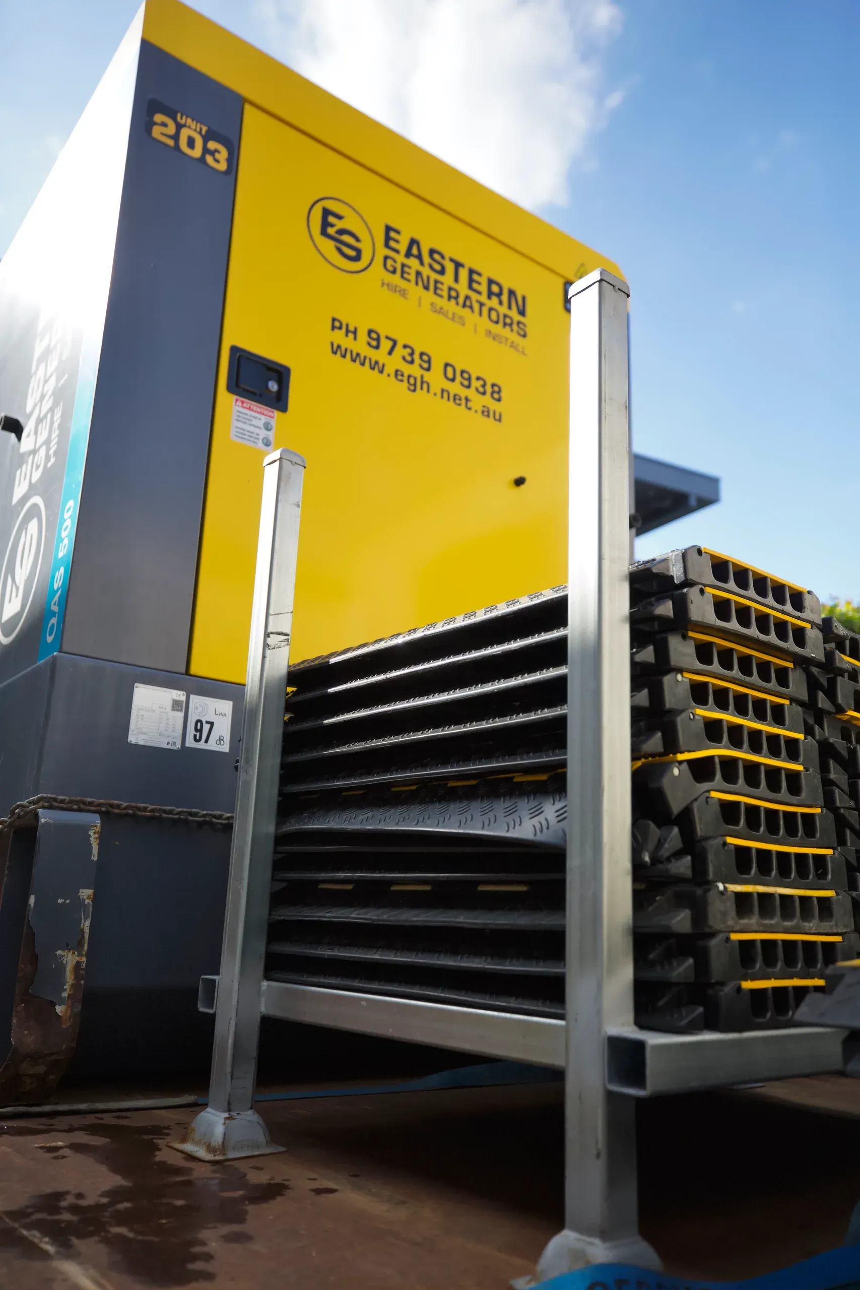 A large Eastern Generators hire set standing on site with cable ramps stacked alongside it