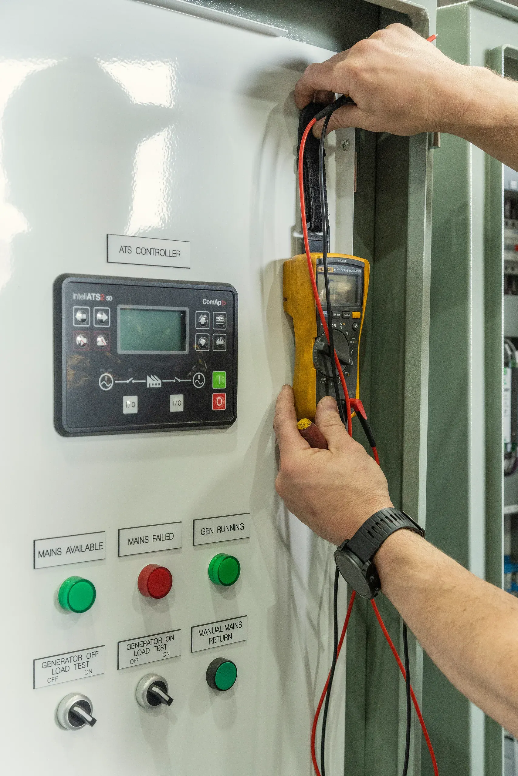An Eastern Generators technician taking a reading from a generator with a multimeter