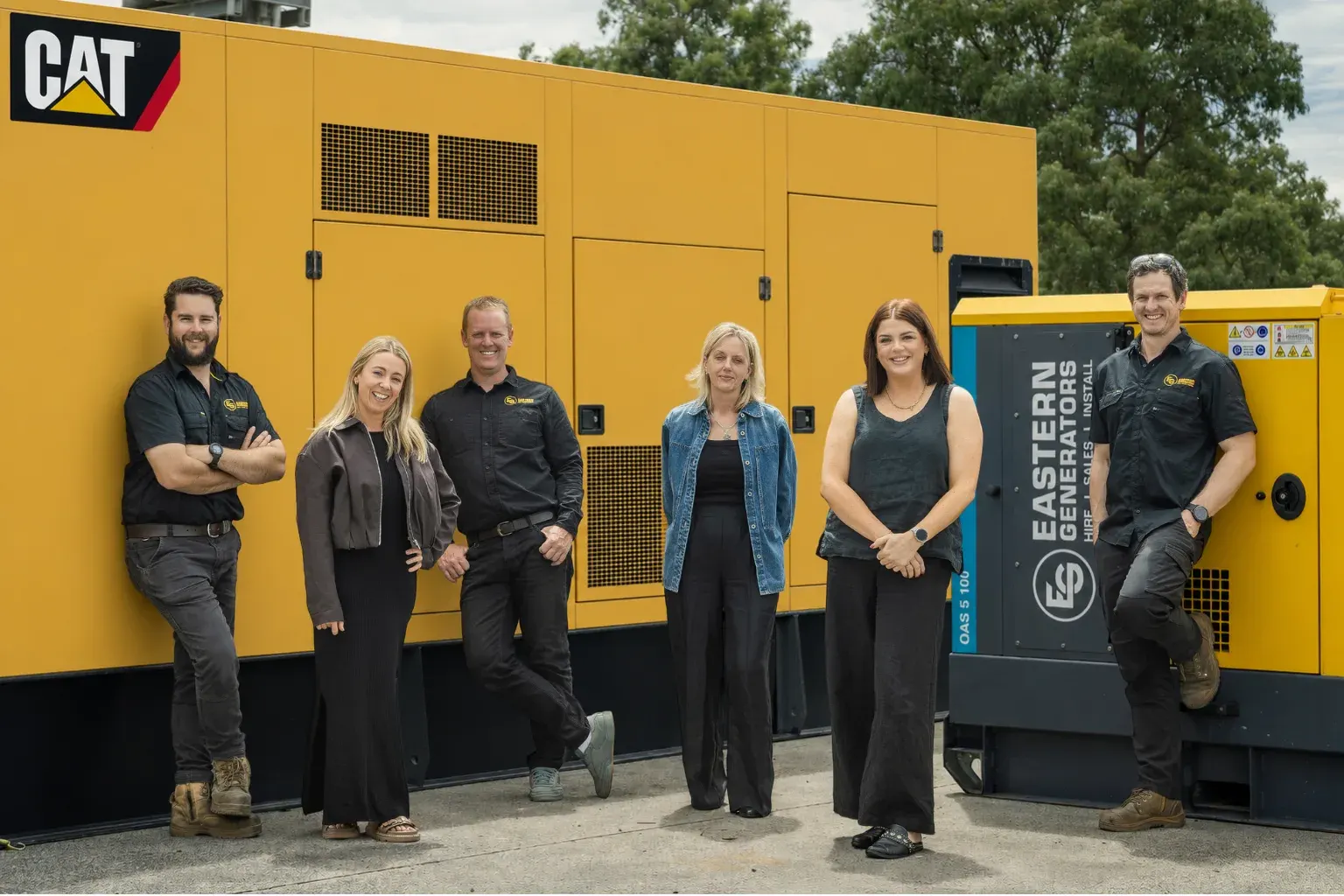The Eastern Generators team in front of a large CAT generator unit